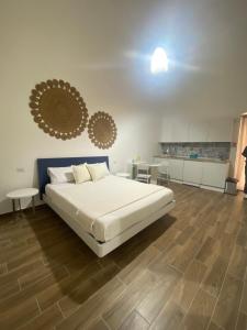 a bedroom with a white bed and a wooden floor at Emme9 in Gaeta