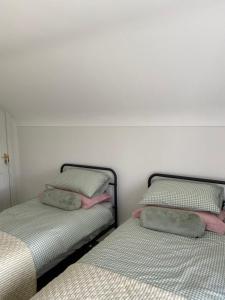 two beds sitting next to each other in a room at The Cottage in Ramelton +4 photos