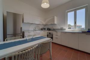 a kitchen with white cabinets and a table with chairs at Casa Bianca - Goelba in Pomonte