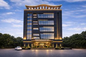 a building with a car parked in front of it at Hotel International Inn - Near Delhi Airport in New Delhi