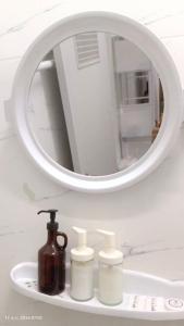 a bathroom sink with a mirror and three soap dispensers at Chic Homestay Narathiwat in Ban Kam Pong Ba Ru