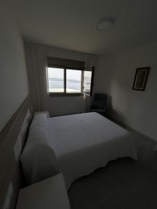 a bedroom with a large bed and a window at Habitaciones A Postiña in Areas +2 photos