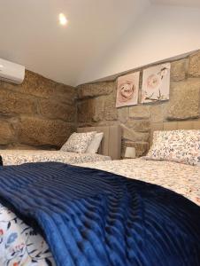 a bedroom with a blue blanket on a bed at Quinta das Flores da Mãe in Folhada +65 photos