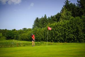 a man standing on a golf course next to a flag at Gästehaus Maasberg in Bad Sobernheim