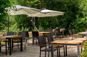 a group of tables and chairs with umbrellas at Gästehaus Maasberg in Bad Sobernheim
