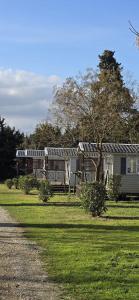 a house with solar panels on top of a yard at Camping Fontisson - Mobil home 3 pièces 4/5 personnes Climatisé MAE-1476 in Châteauneuf-de-Gadagne +11 photos