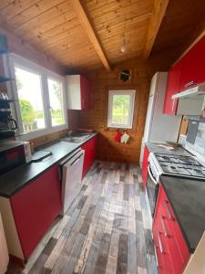 a kitchen with red cabinets and a wooden floor at Chalet Horizon Mer in Conca