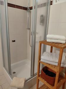 a shower in a bathroom with a wooden shelf with towels at Pension Villa Sophia in Sassnitz +38 photos