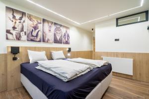 a bedroom with a king sized bed and paintings on the wall at Gîte DDS - Bridge into nature! in Manhay