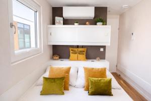 a small living room with yellow and white pillows at Floatinghouse Sunday in Ribnitz-Damgarten