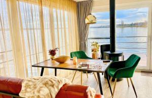 a living room with a table and green chairs at Floatinghouse Sunday in Ribnitz-Damgarten