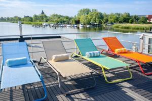 a group of chairs sitting on the deck of a boat at Floatinghouse Sunday in Ribnitz-Damgarten