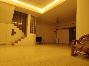an empty room with a staircase and a chair at BM Homestay in Bukit Mertajam