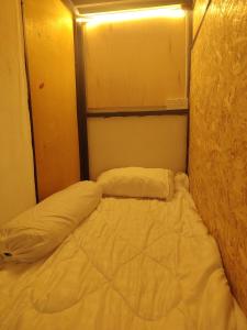 a bed in a small room with two pillows at BM Homestay in Bukit Mertajam