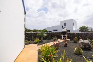 a view of a garden with plants and a building at Villas & Apartamentos Tao Mazo in Lajares +65 photos