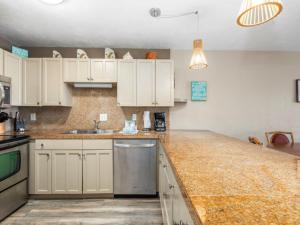 a kitchen with white cabinets and a counter top at Banyan Harbor Resort in Lihue