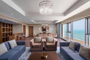 a living room with blue couches and a table at Radisson Blu Hotel & Resort, Sohar in Sohar