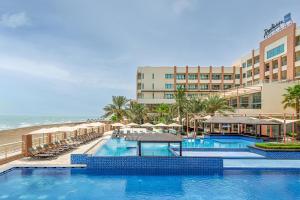 a hotel with a swimming pool next to the beach at Radisson Blu Hotel & Resort, Sohar in Sohar
