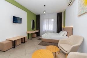 a room with a bed and a couch and a table at Hotel Shkodra L in Shkodër