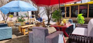 a man sitting at a table under an umbrella at Hotel T-Suru Leh in Leh