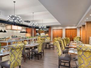 a restaurant with long tables and yellow chairs at ANEW Resort Hunters Rest Rustenburg in Rustenburg