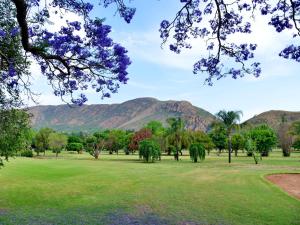 a view of a park with mountains in the background at ANEW Resort Hunters Rest Rustenburg in Rustenburg +197 photos