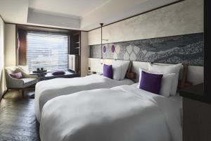 a hotel room with two beds with purple pillows at Dhawa Yura Kyoto in Kyoto
