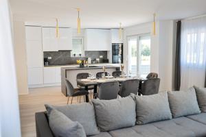 a living room and kitchen with a couch and a table at Villa IviCasa with pool in Murvica