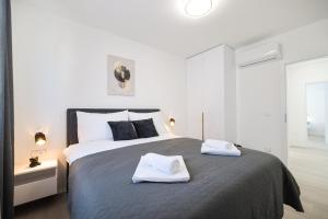 a bedroom with a large bed with two towels on it at Villa IviCasa with pool in Murvica +81 photos