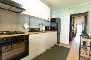 a kitchen with white cabinets and a black appliances at DouroParadise Apartment in Peso da Régua +18 photos