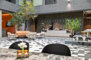 a lobby with tables and chairs and a kitchen at Comfort Hotel Porsgrunn in Porsgrunn