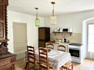 a kitchen with a table and chairs and a kitchen with a refrigerator at Housica & Co. in Ucciani