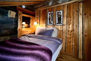a bedroom with a bed with a purple blanket at Exclusive Cabin with lovly Northern Lights Views in Kilpisjärvi