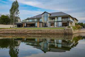 a house with a reflection in the water at 3066 Water Edge in Parys