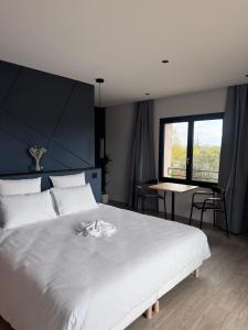 a bedroom with a large white bed and a table at Gîtes les rives de Saône in Saint-Didier-sur-Chalaronne