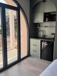 a kitchen with sliding glass doors and a sink at Gîtes les rives de Saône in Saint-Didier-sur-Chalaronne