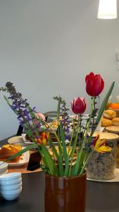 a vase filled with flowers on a table with food at Cascina Ricardin in Coazzolo