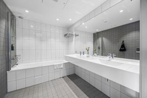 a bathroom with two sinks and a large mirror at Comfort Hotel Porsgrunn in Porsgrunn +32 photos