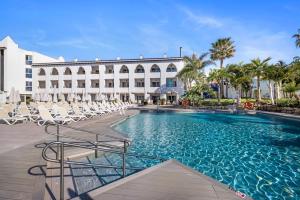 a large swimming pool with chairs and a building at Mac Puerto Marina Benalmádena in Benalmádena
