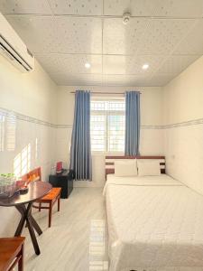 a bedroom with a large bed and a table at Homestay Đức Thạnh in Rạch Giá