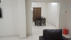 a living room with a black chair and a table at Hotel Tamilnadu Trichy in Tiruchirappalli