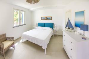 a bedroom with a bed and a dresser with a blue pillow at Villa Giannetta in Canneto