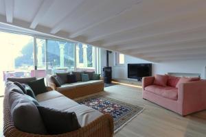 a living room with two couches and a television at Hotel Giardino Verdi in Riva del Garda