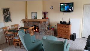a living room with a fireplace and a table and chairs at Domek w pięknej okolicy in Chmielów