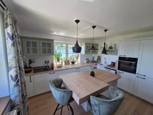a kitchen with a wooden table and chairs at Haus Königsreiter, der besondere Platz in Altmünster
