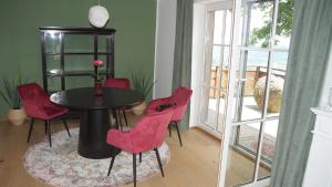 a dining room with a table and red chairs at Haus Königsreiter, der besondere Platz in Altmünster +2 photos