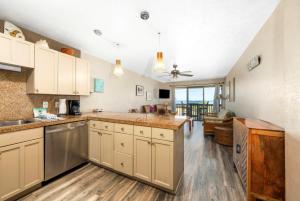 a large kitchen with white cabinets and a living room at Banyan Harbor Resort in Lihue