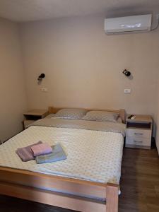 a bedroom with two beds and a air conditioner at Konaci kod Bobe in (( Vratna ))