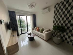 a living room with a couch and a table at Hue Oi 5 Homestay - Spacious 2-Bedroom Apartment with Balcony & Pool in Hue