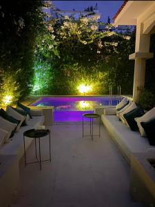a patio with two tables and a pool at night at Riad Sebti Fès in Fez